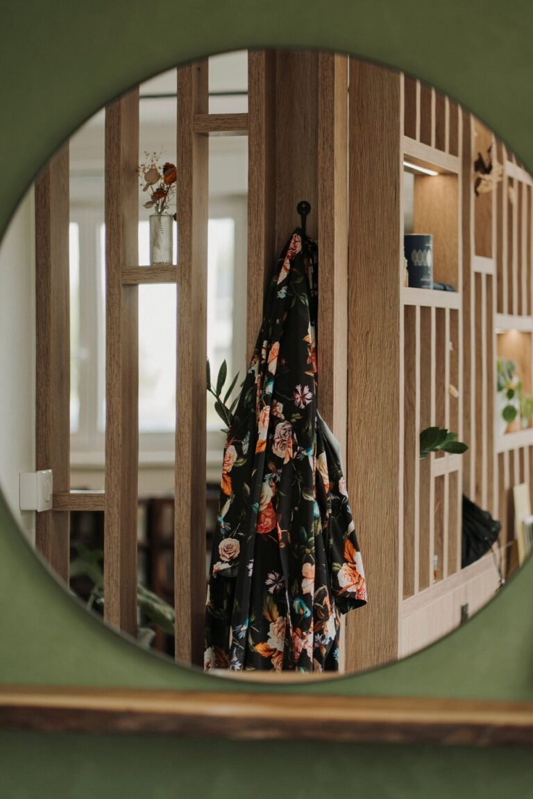 Peignoir fleuri reflété dans un miroir rond du salon Maison H