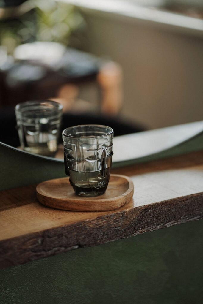 Verre d'eau posé sur une étagère en bois dans le salon Maison H