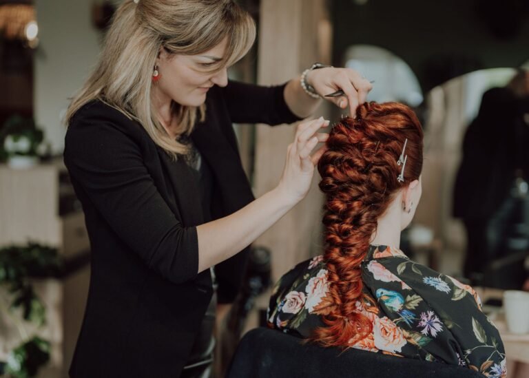 Coiffeuse réalisant une tresse sur cheveux roux chez Maison H